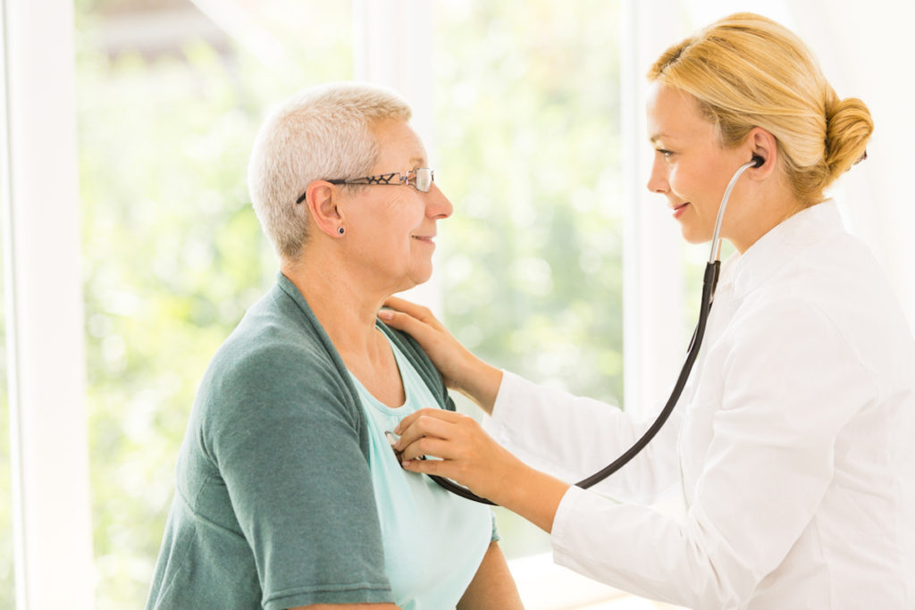 Female Doctor checking senior woman