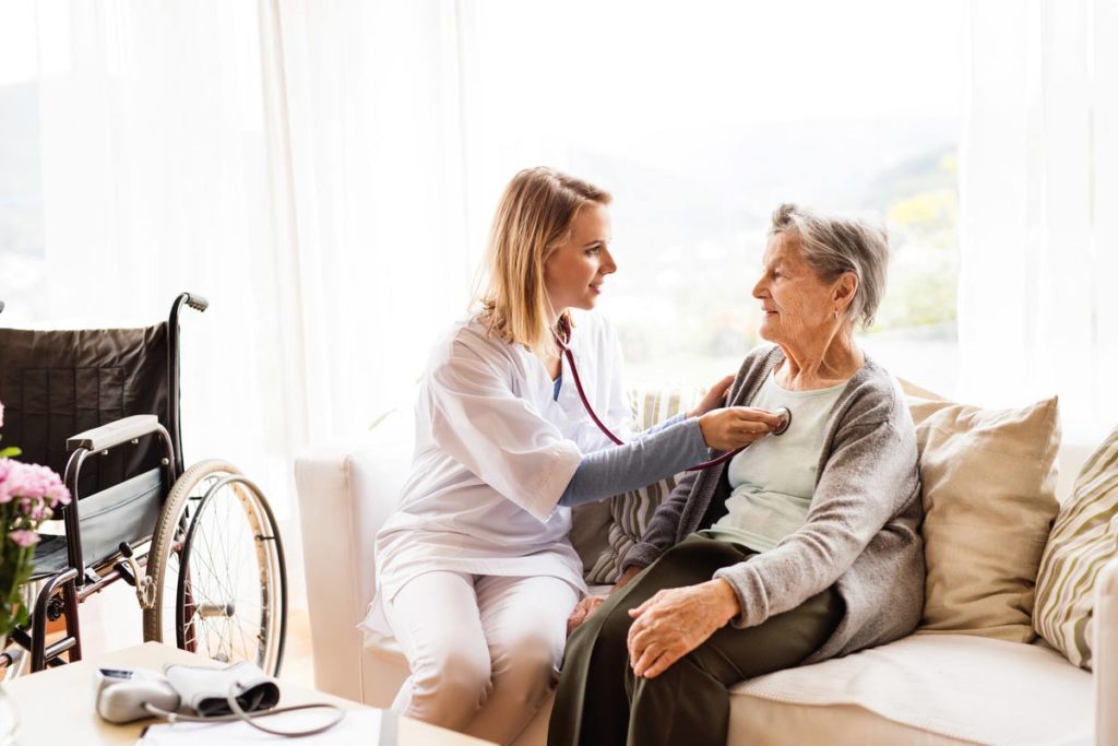 elderly woman at home being check on by caregiver