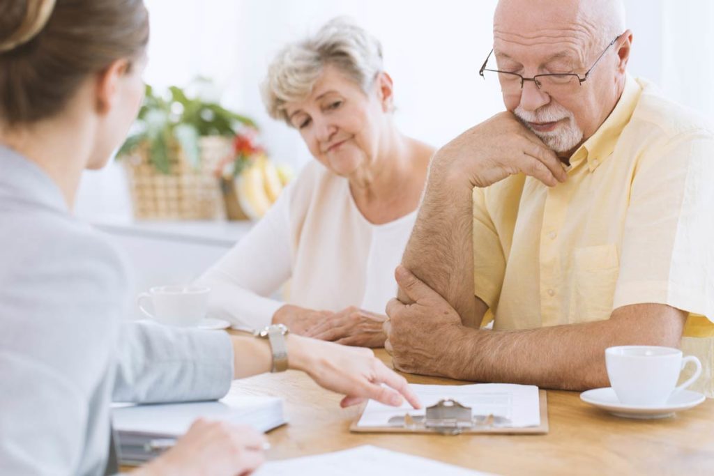 Elderly couple filling out paper work burial insurance