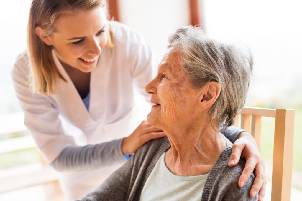 Health visitor and a senior woman during home visit. A nurse or a doctor examining a woman