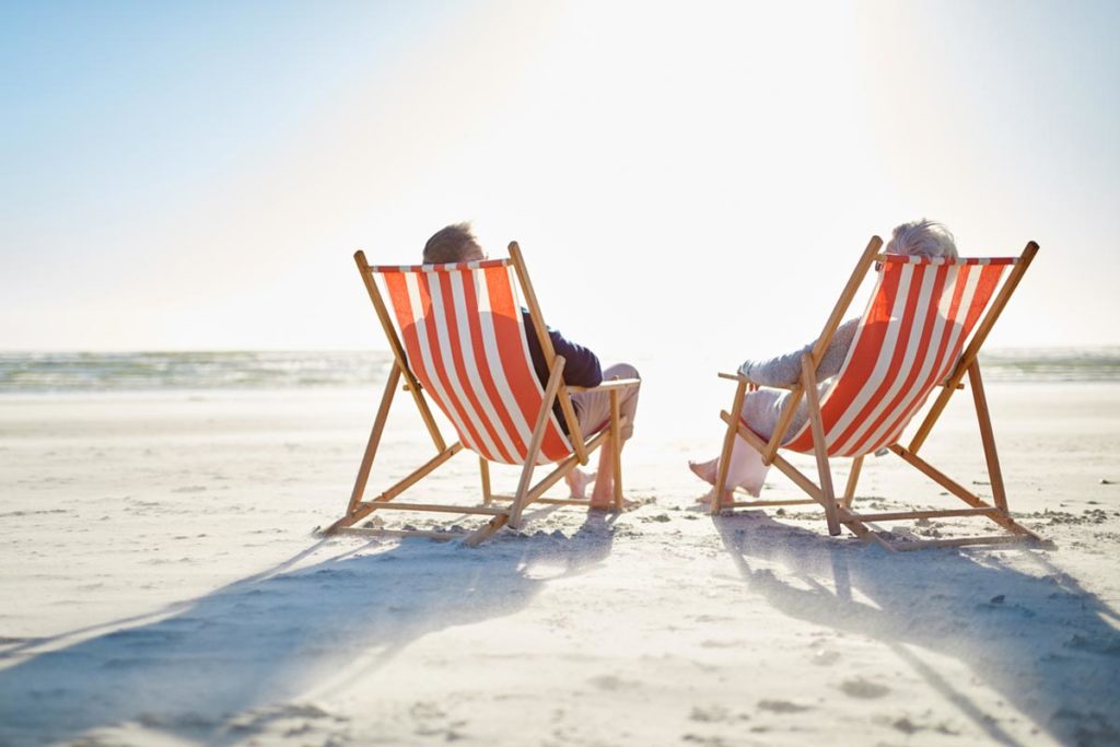 elderly couple enjoying retirement on beach