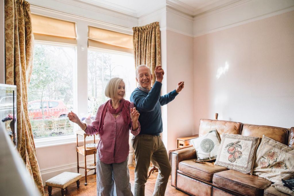 senior couple dancing in living room