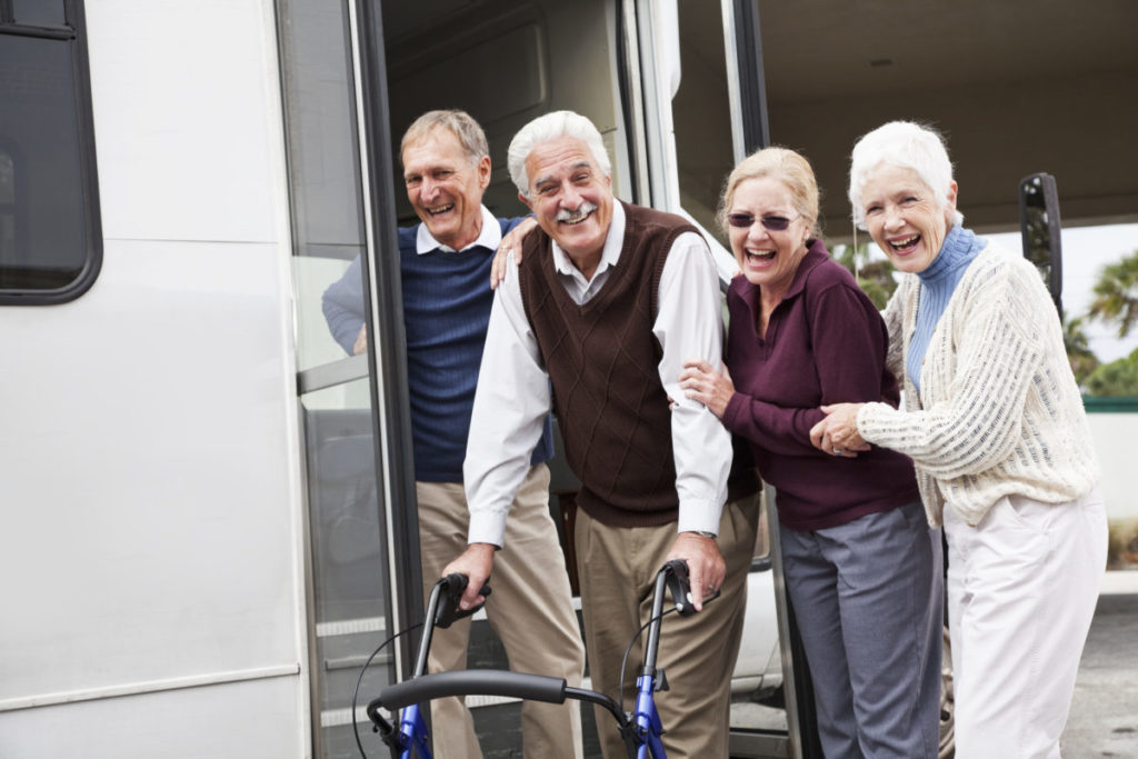 Two senior couples outside shuttle bus