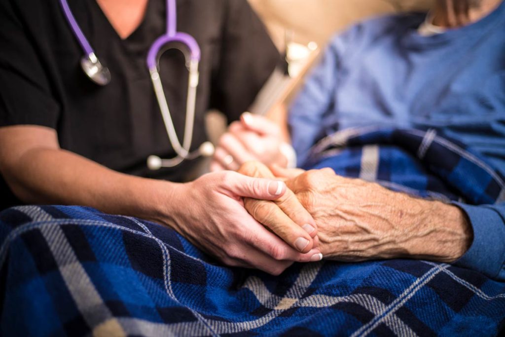 Seniors with nurse holding hands