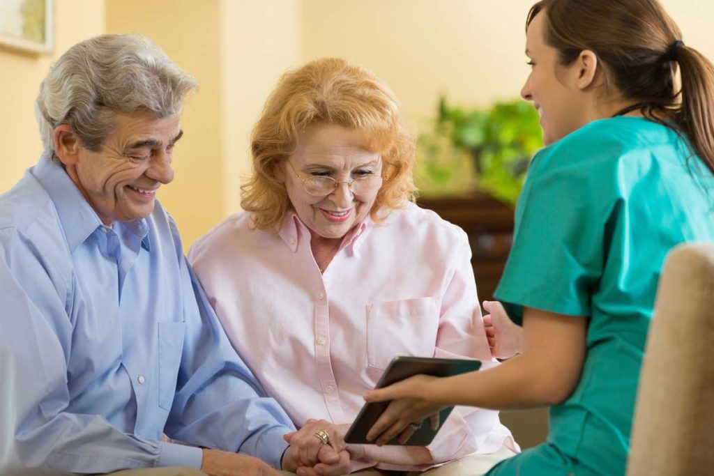 Elderly couple talking to nurse