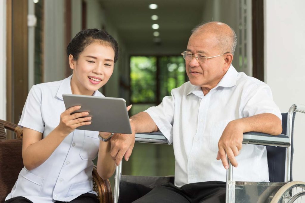 senior talking with nurse looking at tablet