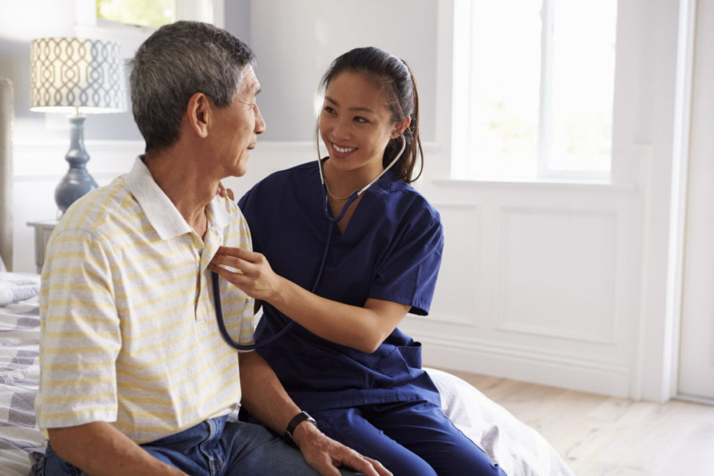 East Asian female nurse taking care of Asian male patient