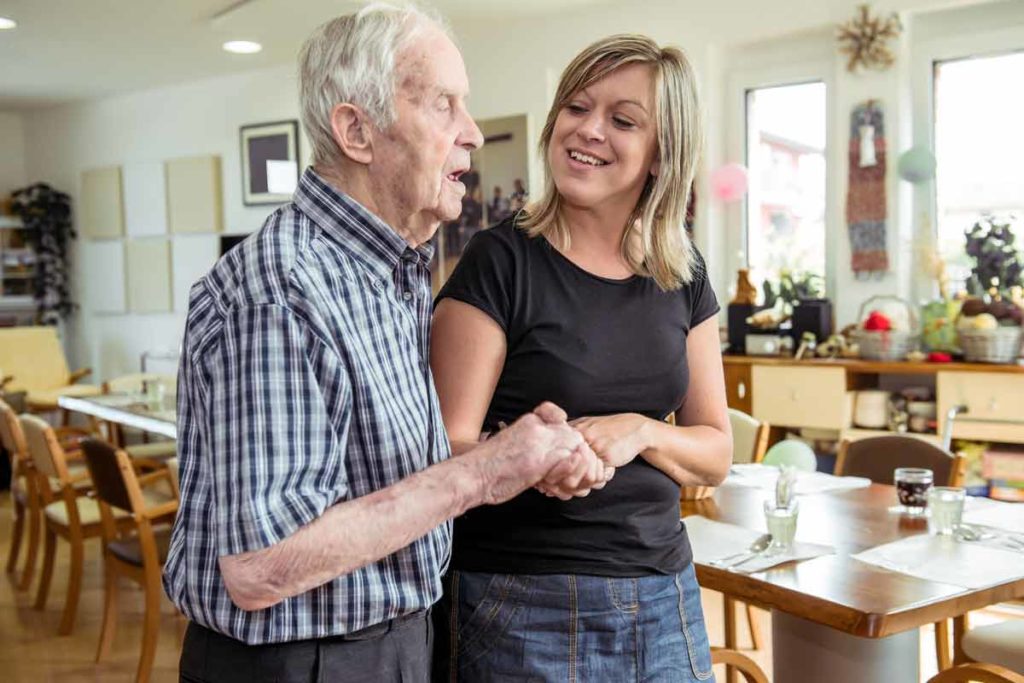 woman walking with senior at an adult day care center