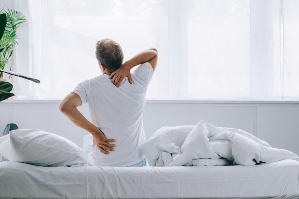 A man sitting on an adjustable bed