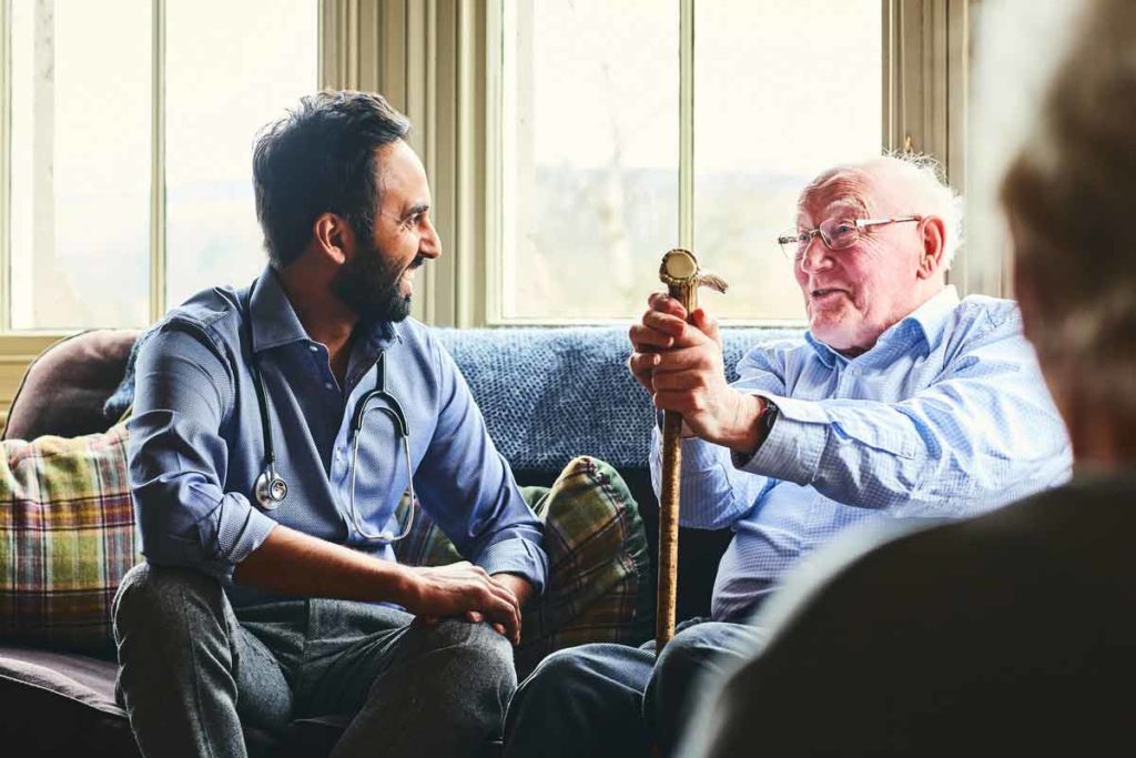 doctor talking to senior man at home