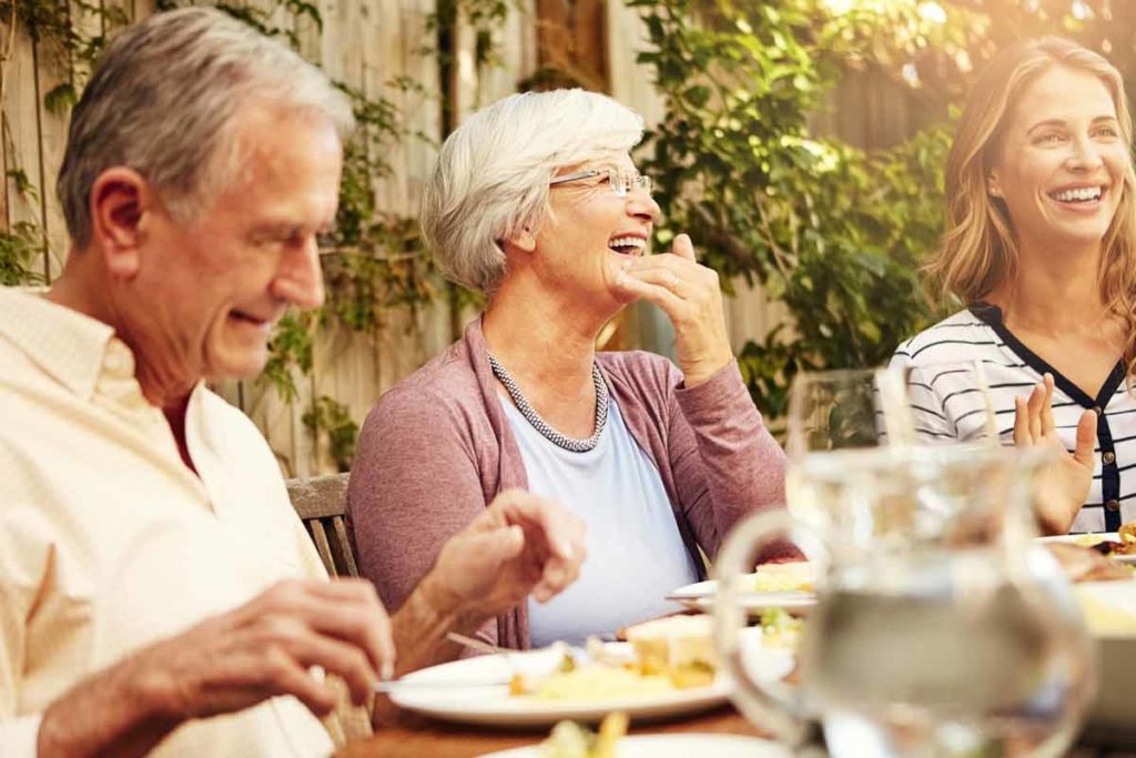 senior couple eating with family