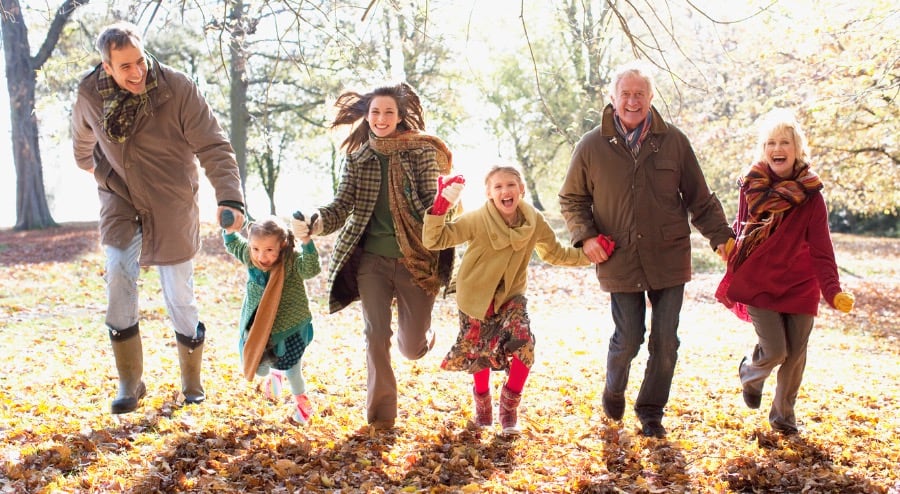 Family running in the park during Autumn