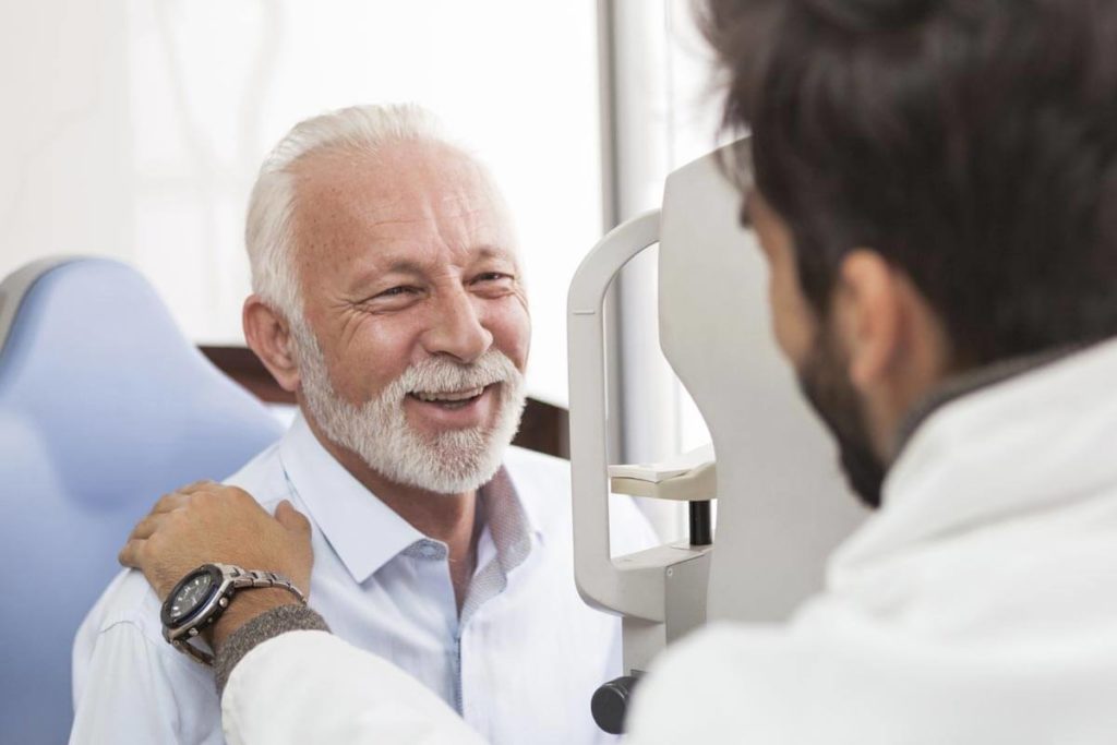 eye doctor talking to senior man