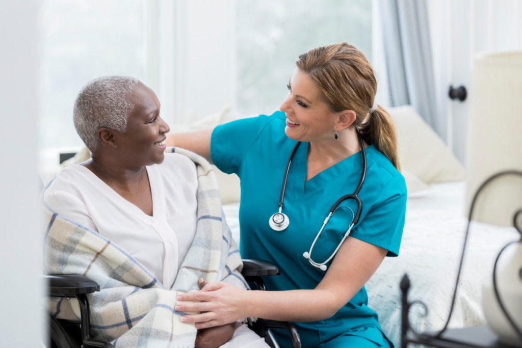 Caucasian nurse taking care of African patient