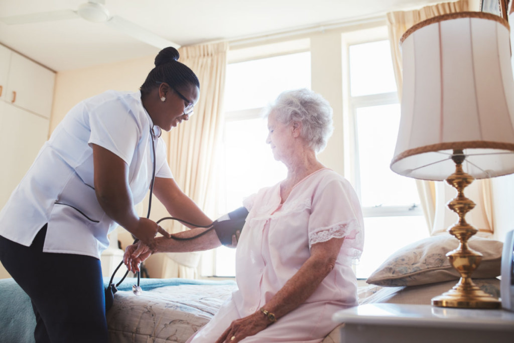 Nurse checking blood pressure of female patient