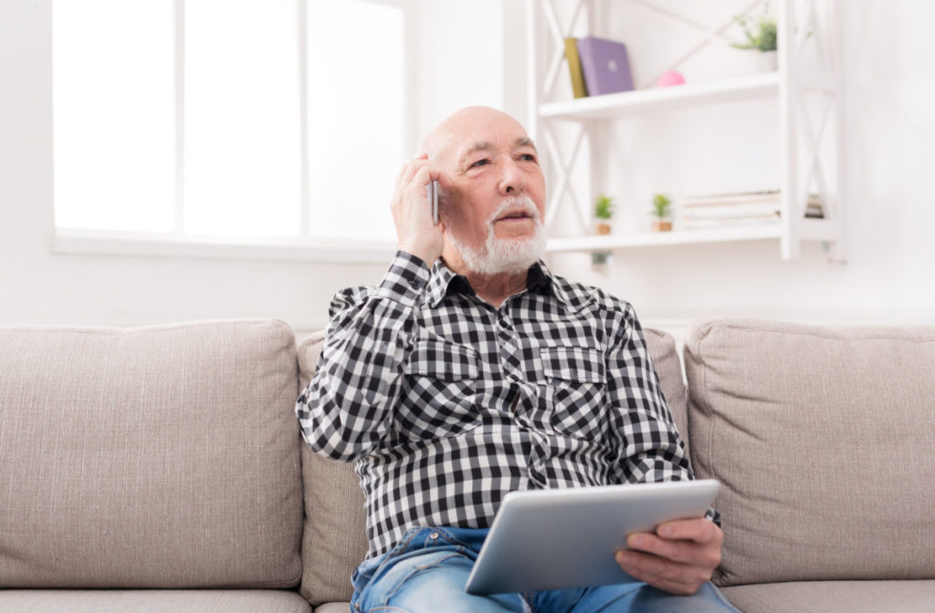 Senior man talking on phone with tablet