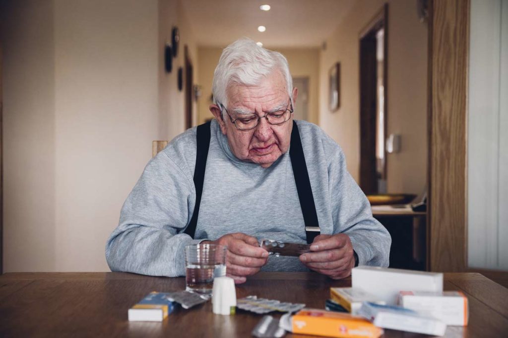 older man counting out his medication