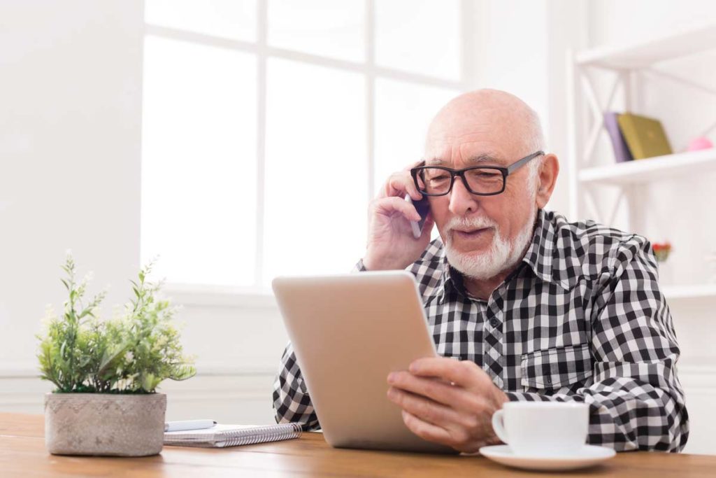 older man on phone and tablet