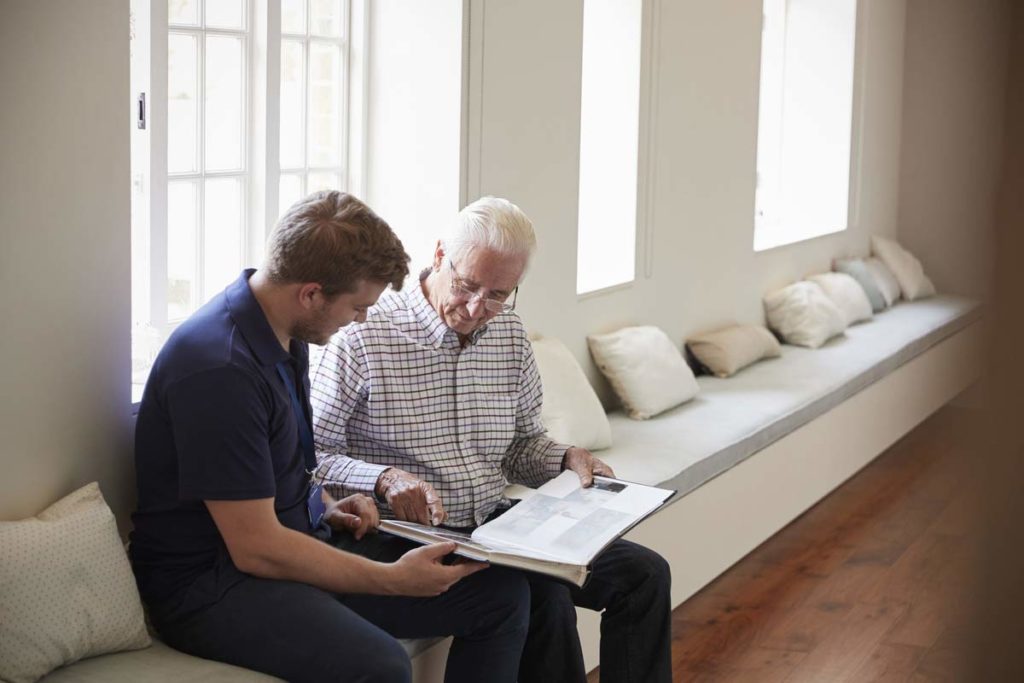 older man showing hospice nurse a photo album