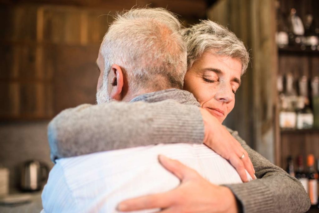 senior couple embracing in kitchen