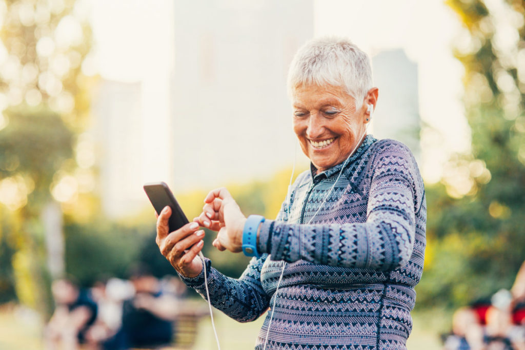 Senior sportswoman looking at her smart watch outdoors.