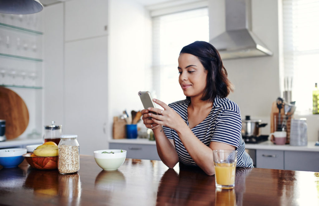 young woman using her cellphone at home